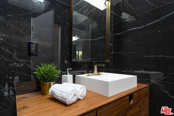 a view of bathroom with a sink and mirror
