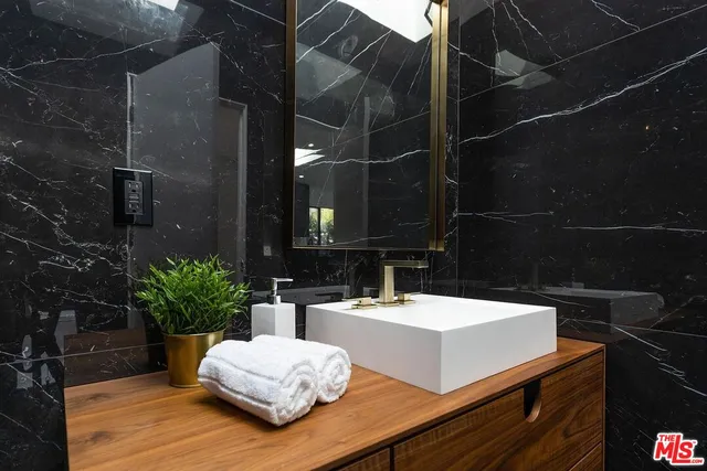 a view of bathroom with a sink and mirror