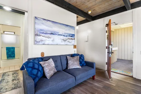 a living room with furniture and a wooden floor