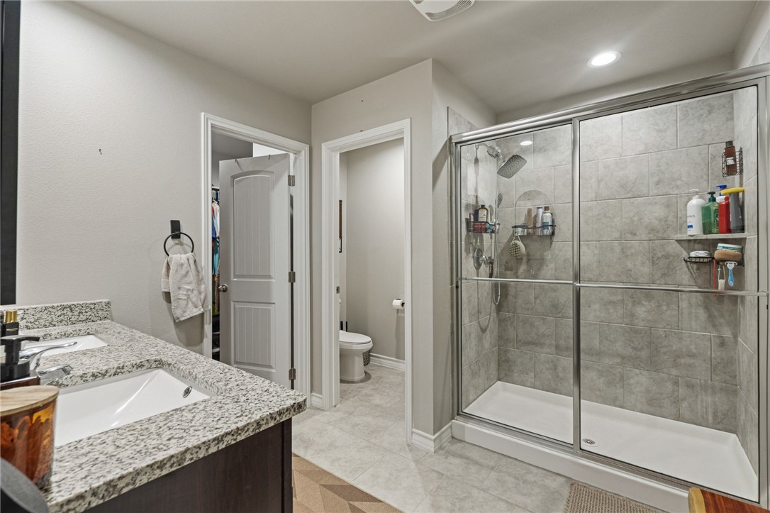 103 Donegal Street Sinton, TX 78387 - Photo 22 of 29 a bathroom with a granite countertop sink mirror and shower