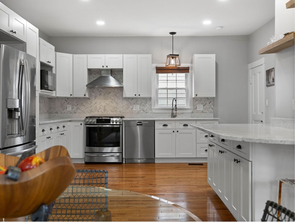 299 Central Avenue Dedham, MA 02026 - Photo 15 of 39 a kitchen with stainless steel appliances granite countertop a stove a sink and a refrigerator