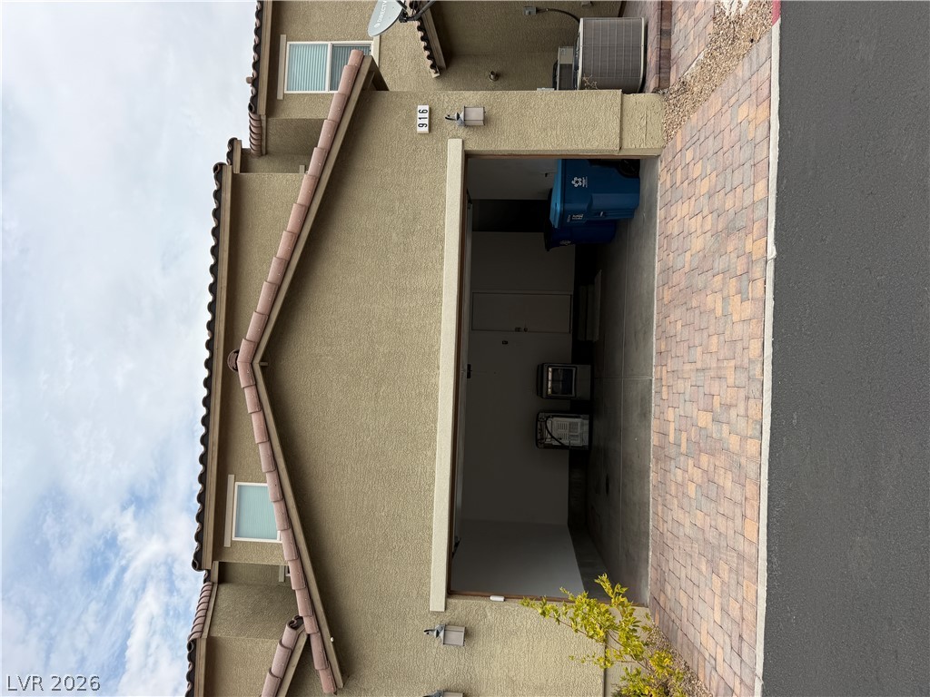 916 Riggs Flats Avenue North Las Vegas, NV 89086 - Photo 37 of 43 An attached garage opens onto a paved driveway under a classic tiled roofline.