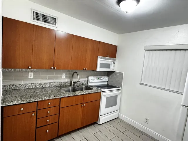 a kitchen with stainless steel appliances granite countertop a sink stove and cabinets