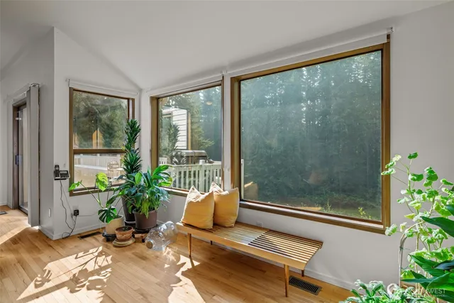 a living room with a balcony a bed and a potted plant