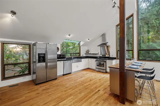 a kitchen with stainless steel appliances a refrigerator and a stove top oven