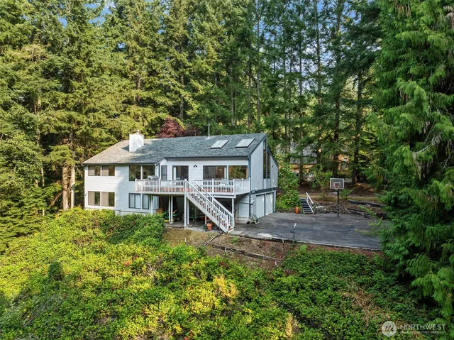 a front view of a house with a garden and trees