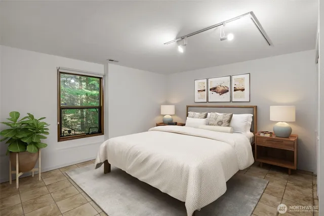 a bedroom with a large bed and a potted plant