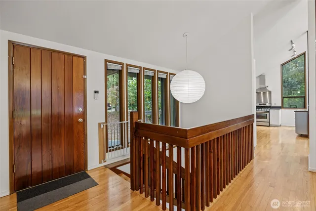 a view of a hallway with wooden floor and windows