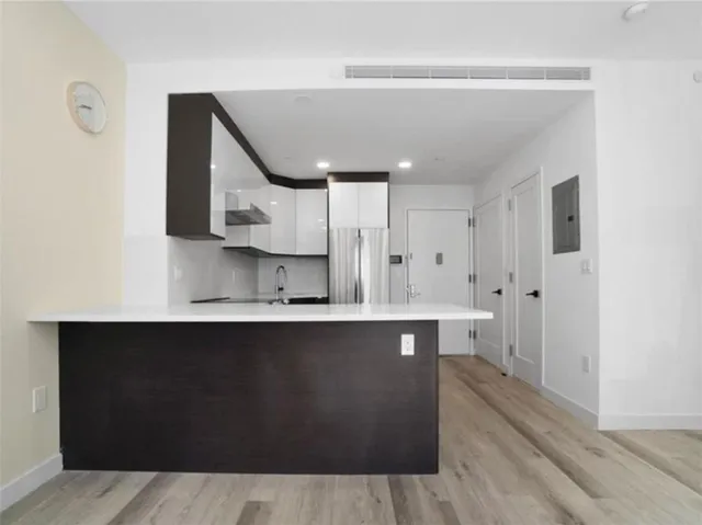 a large kitchen with stainless steel appliances a sink and cabinets