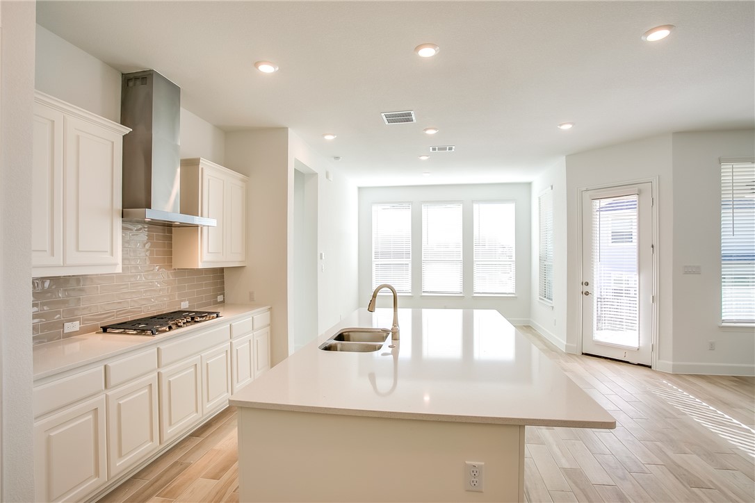 505 Affazia Lane Georgetown, TX 78628 - Photo 12 of 32 a view of a kitchen with kitchen island a sink wooden floor and counter top space