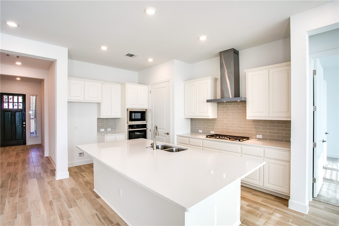 505 Affazia Lane Georgetown, TX 78628 - Photo 13 of 32 a kitchen with stainless steel appliances a stove a sink a refrigerator and cabinets
