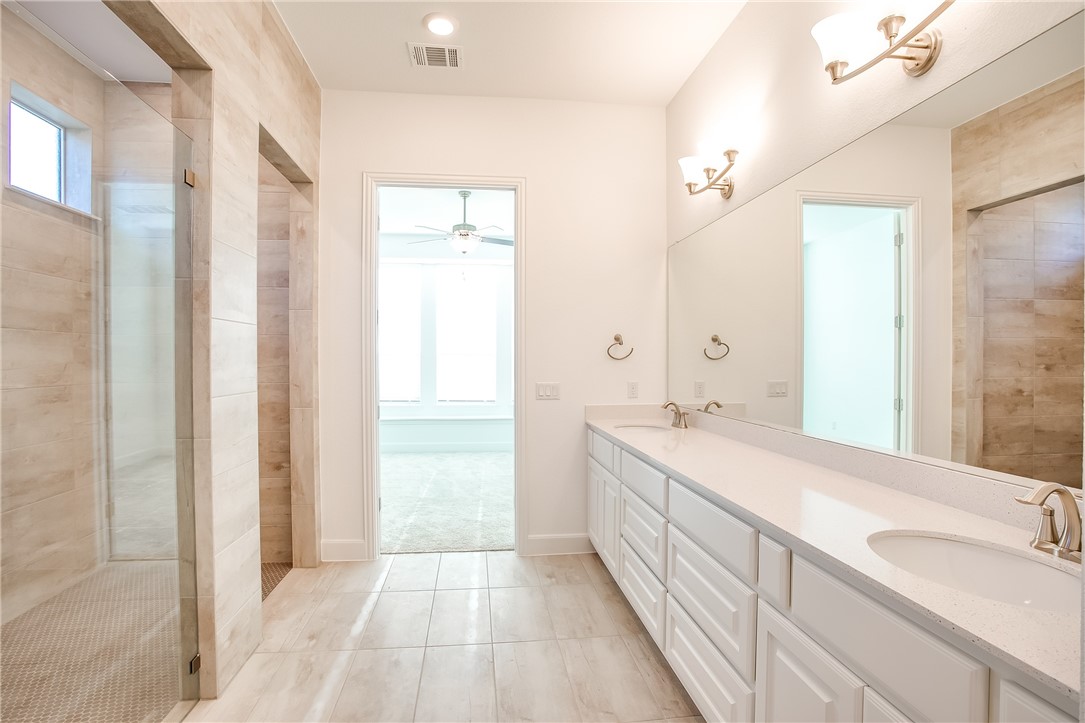 505 Affazia Lane Georgetown, TX 78628 - Photo 21 of 32 a spacious bathroom with a double vanity sink a mirror and a shower