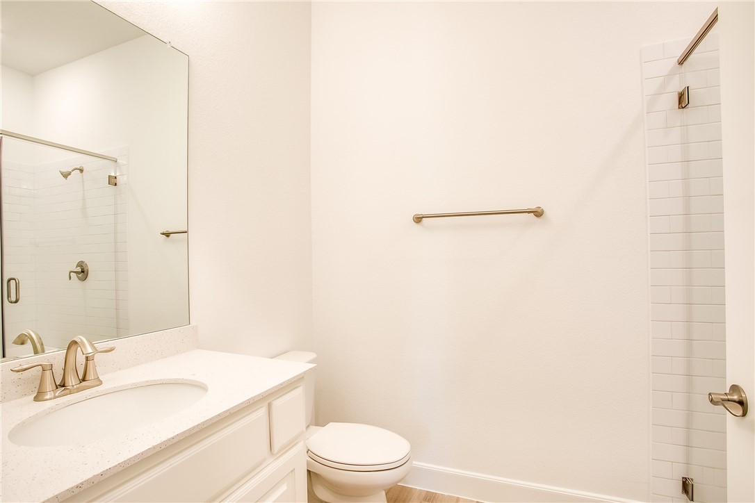 505 Affazia Lane Georgetown, TX 78628 - Photo 24 of 32 a bathroom with a granite countertop sink toilet and a mirror