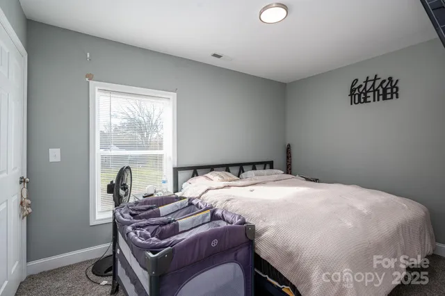 a bed sitting in a bedroom next to a window