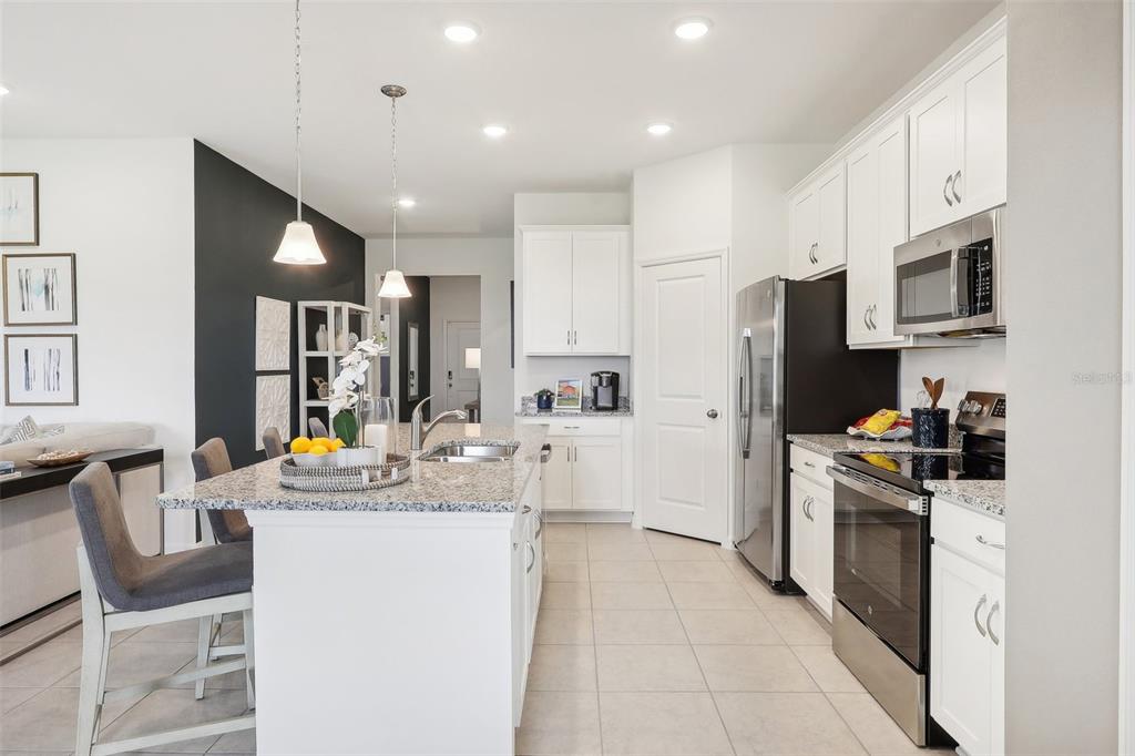 1885 Shadow Box Bend St. Cloud, FL 34771 - Photo 15 of 45 a kitchen with white cabinets and stainless steel appliances