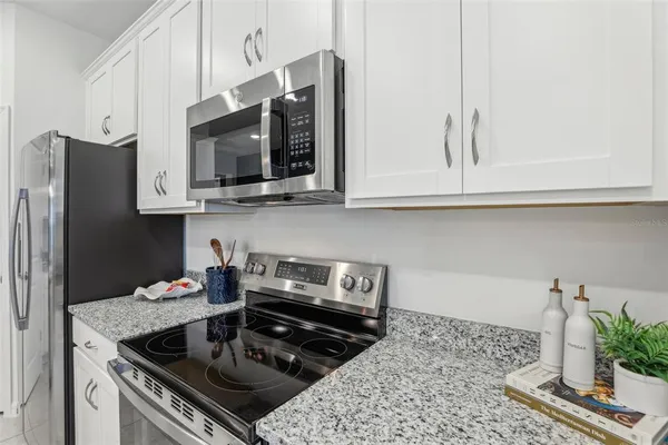 a kitchen with stainless steel appliances granite countertop a stove a microwave and cabinets
