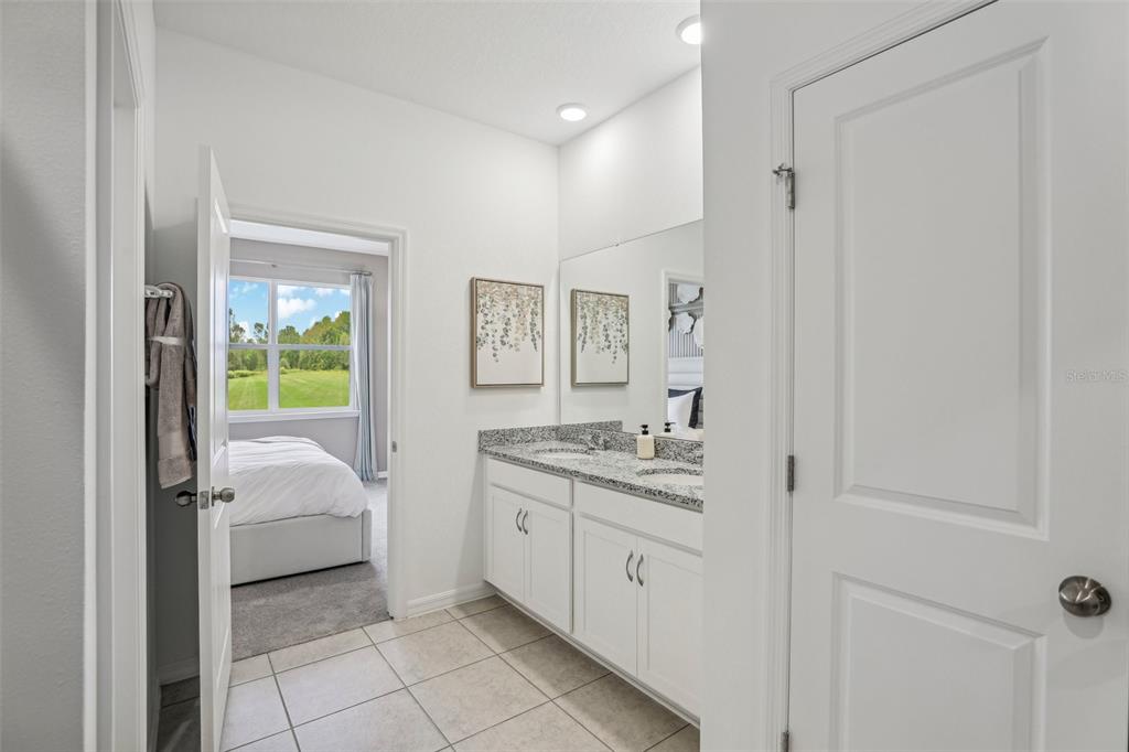 1885 Shadow Box Bend St. Cloud, FL 34771 - Photo 30 of 45 a en suite bathroom with a granite countertop sink and a mirror