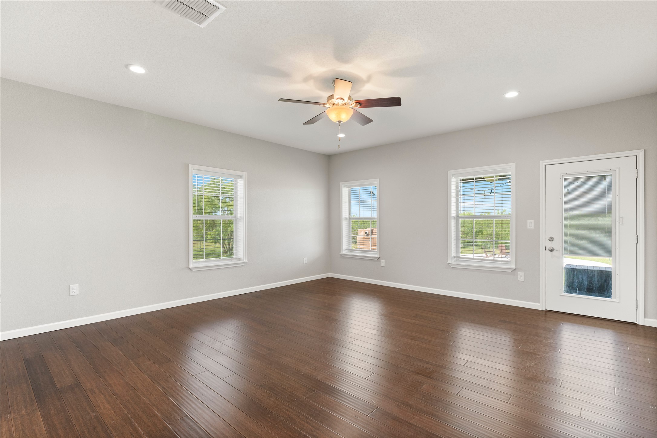 1293 Pioneer Road Seguin, TX 78155 - Photo 14 of 40 Ample windows illuminate this spacious room with elegant hardwood flooring and a functional ceiling fan.
