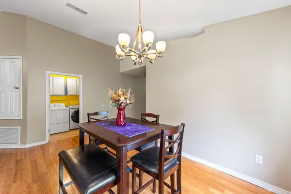 a dining room with furniture a chandelier and wooden floor