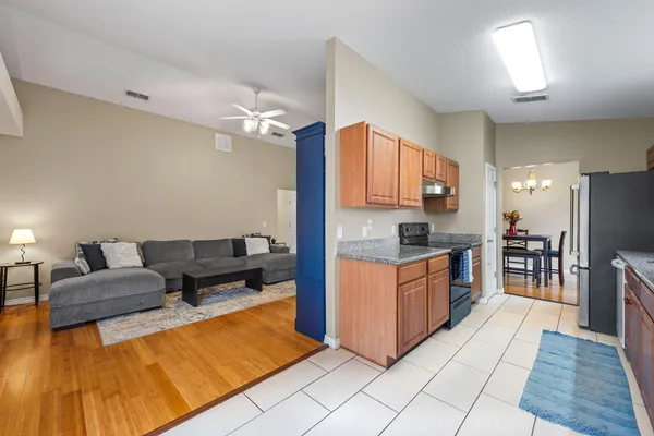 a kitchen with stainless steel appliances kitchen island granite countertop a refrigerator and a stove top oven