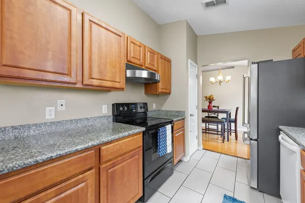a kitchen with stainless steel appliances granite countertop a stove a sink and a microwave