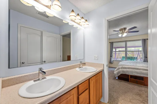 a en suite bathroom with a double vanity sink and a mirror