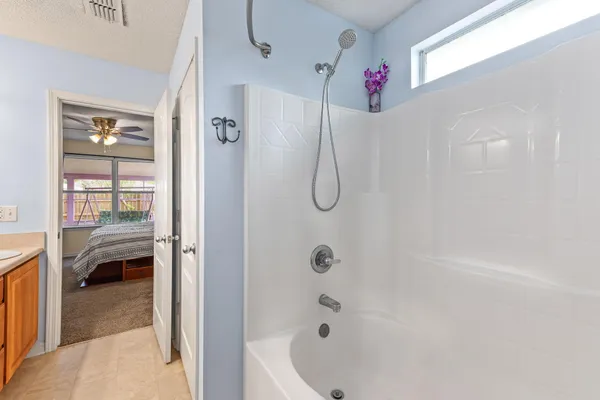 a bathroom with a tub a window and a shower
