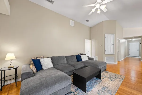 a living room with furniture and a wooden floor