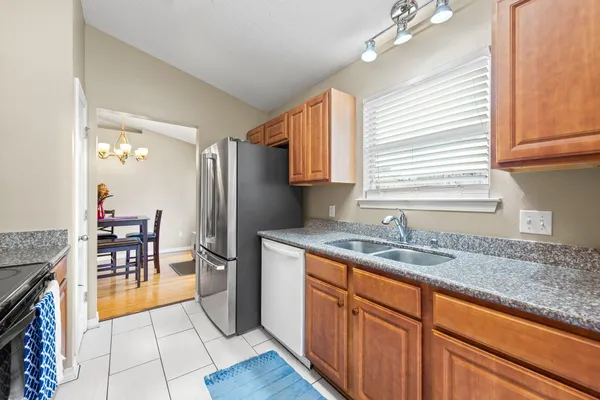 a kitchen with stainless steel appliances granite countertop a sink refrigerator and cabinets