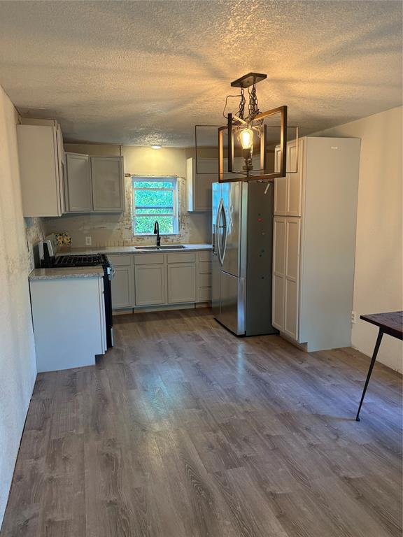 616 Breckenridge Highway Ranger, TX 76470 - Photo 7 of 16 a kitchen with stainless steel appliances granite countertop a refrigerator a sink dishwasher a stove and white cabinets with wooden floor
