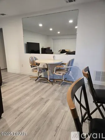 a kitchen with stainless steel appliances granite countertop a table chairs sink refrigerator and microwave