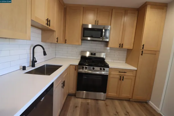 a kitchen with a sink a stove and cabinets