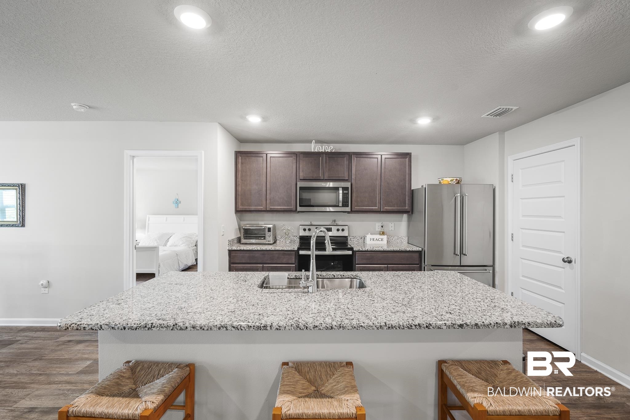 10232 Brodick Loop Spanish Fort, AL 36527 - Photo 12 of 29 Kitchen featuring appliances with stainless steel finishes, a sink, a breakfast bar area, dark brown cabinets, and recessed lighting