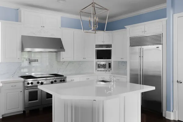 a kitchen with stainless steel appliances a sink a stove a refrigerator and cabinets