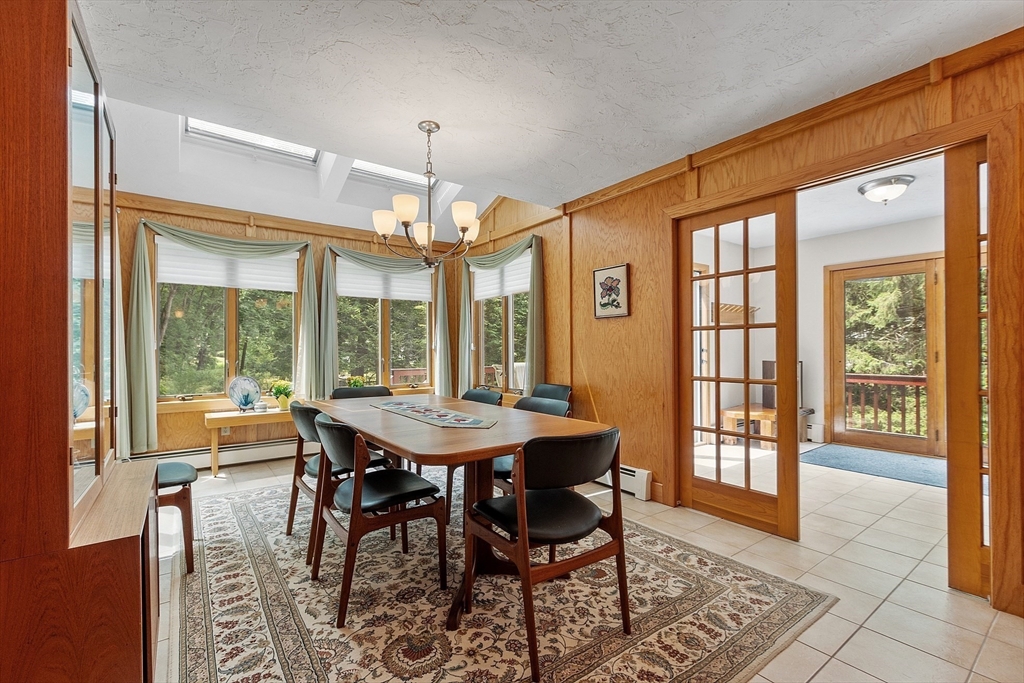 624 Old Harvard Road Boxborough, MA 01719 - Photo 12 of 42 a view of a dining room with furniture large windows and wooden floor