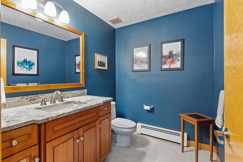 624 Old Harvard Road Boxborough, MA 01719 - Photo 16 of 42 a bathroom with a granite countertop toilet sink and mirror
