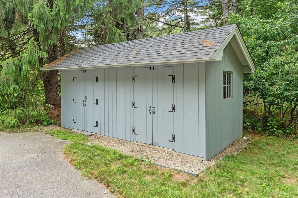 624 Old Harvard Road Boxborough, MA 01719 - Photo 36 of 42 a view of a wooden house with a small yard and large tree