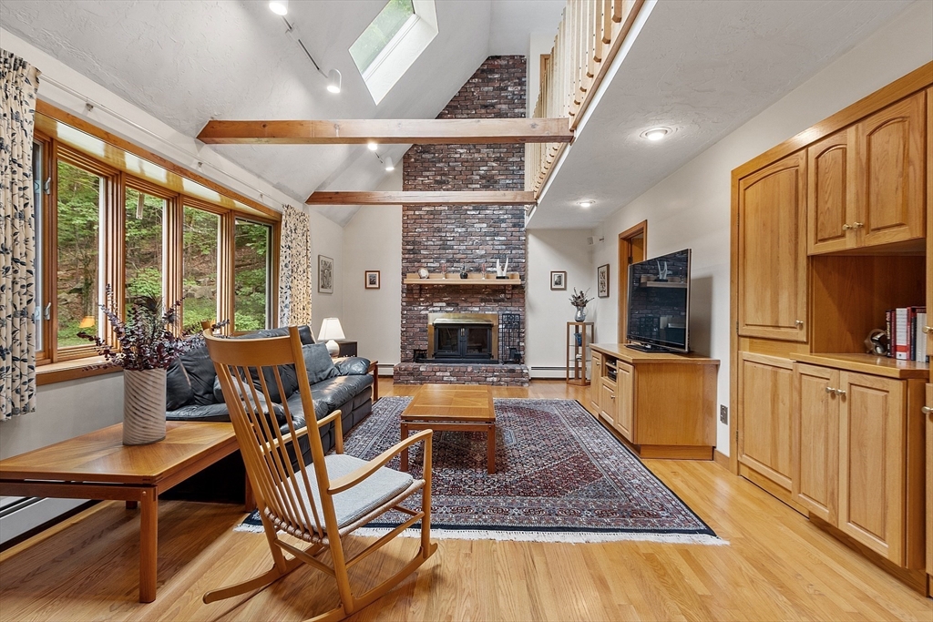 624 Old Harvard Road Boxborough, MA 01719 - Photo 5 of 42 a living room with furniture a fireplace and a flat screen tv