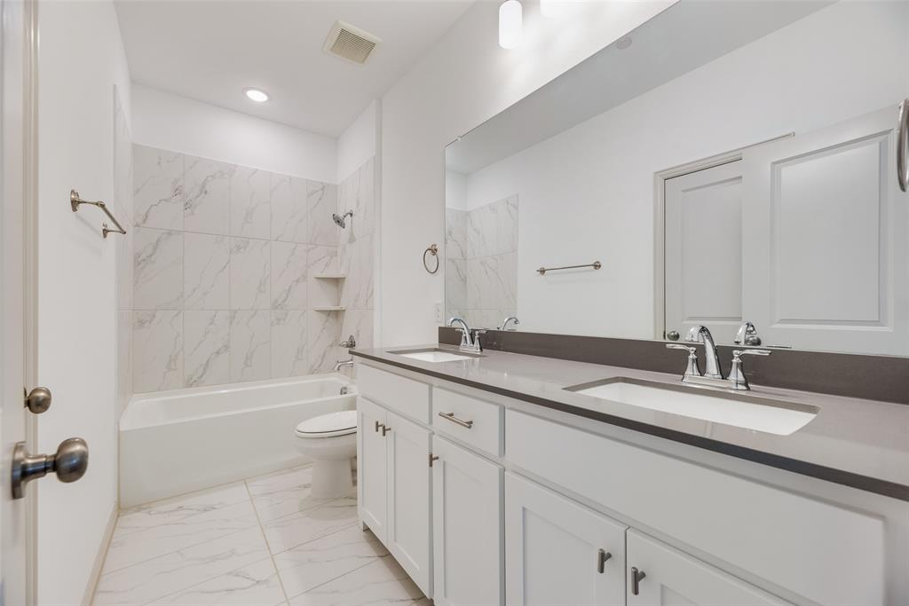9005 Phoebe Road Frisco, TX 75035 - Photo 14 of 23 a bathroom with a granite countertop sink a toilet a mirror and shower