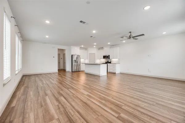 a view of kitchen and hall with wooden floor