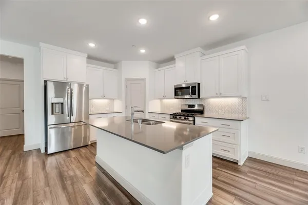 a kitchen with cabinets and stainless steel appliances