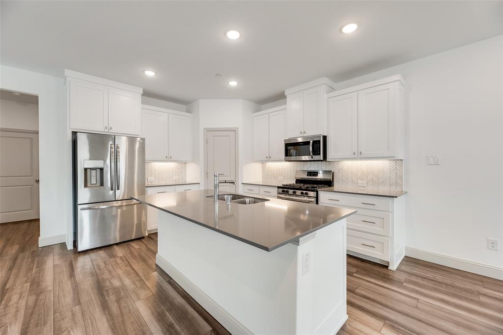 9005 Phoebe Road Frisco, TX 75035 - Photo 8 of 23 a kitchen with cabinets and stainless steel appliances