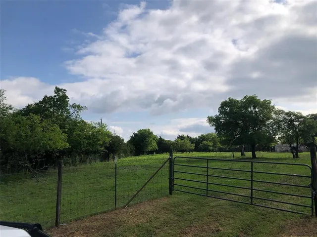 a view of a green field with lots of bushes