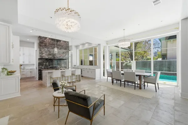 a living room with furniture a chandelier and a large window