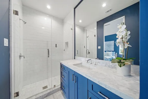 a bathroom with a granite countertop sink a mirror and a shower