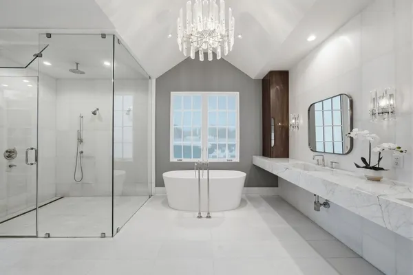 a spacious bathroom with a double vanity sink a large mirror and shower