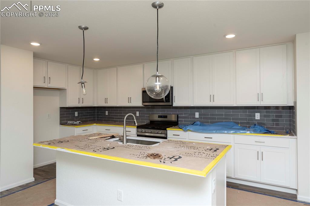 644 Felicity Loop Castle Rock, CO 80109 - Photo 9 of 23 a kitchen with kitchen island granite countertop a sink a counter top space and cabinets