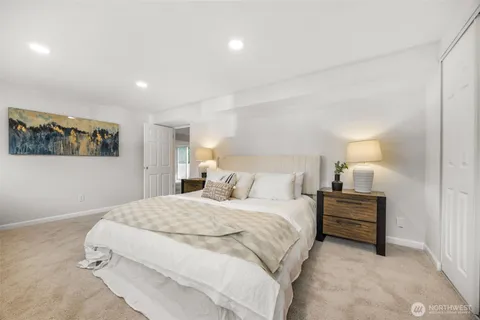 a bedroom with a bed and painting on the wall