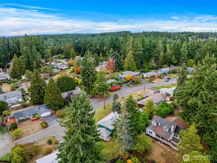 an aerial view of a city with lots of residential buildings ocean and mountain view in back