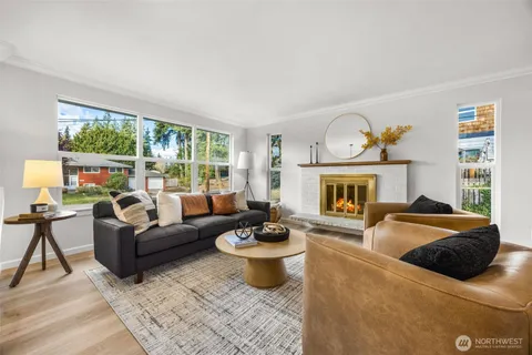 a living room with furniture fireplace and a large window